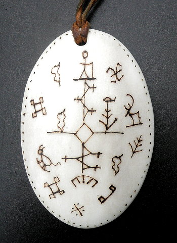 Samen-Amulett aus Knochen mit Abbildungen mythischer Wesen, wie sie auch auf den Zaubertrommeln abgebildet sind.